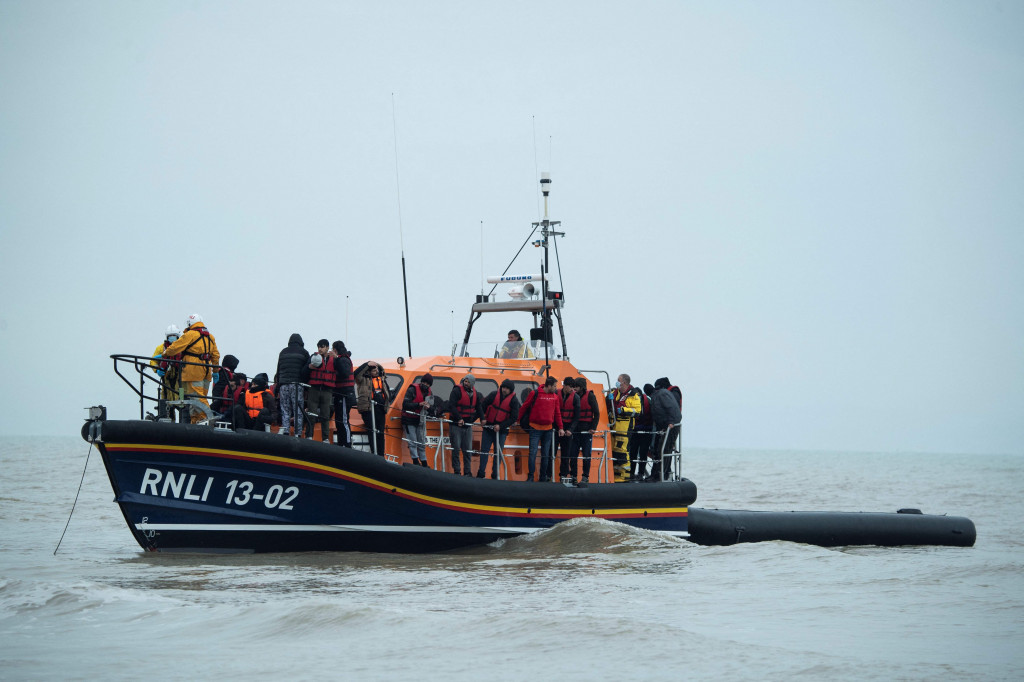 Para migran berdiri di atas sekoci RNLI (Royal National Lifeboat Institution) setelah diselamatkan saat menyebrangi Selat Inggris di lepas pantai di Dungeness, Inggris tenggara, Rabu, 24 November 2021.
