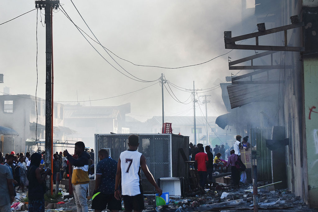 Saat hujan turun di sore hari, pihak berwenang setempat bergerak untuk membasmi bara kekerasan, menyatakan jam malam di Honiara yang akan tetap berlaku sampai dicabut.
