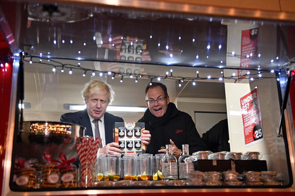 Perdana Menteri Inggris Boris Johnson (kiri) berpose di sebuah truk makanan selama kunjungannya ke pasar Makanan dan Minuman Inggris yang didirikan di Downing Street, London pusat pada 30 November 2021.
