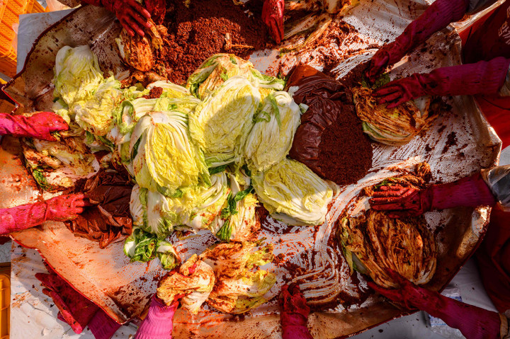 Relawan mencampurkan bahan-bahan saat membuat kimchi untuk disumbangkan kepada yang membutuhkan di sebuah kuil di Seoul, Korea Selatan, Kamis, 2 Desember 2021.