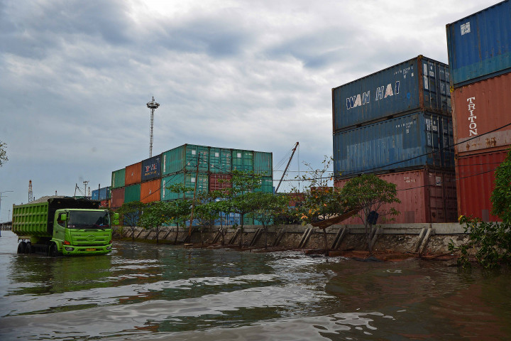 Truk melintasi jalan yang tergenang akibat naiknya air laut ke permukaan (rob) di kawasan Pelabuhan Sunda Kelapa, Jakarta, Jakarta, Minggu, 5 Desember 2021.