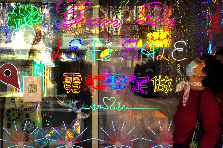 Seorang wanita berjalan melewati toko yang menjual barang-barang Natal di sebuah pasar di Taipei, Taiwan, Rabu, 8 Desember 2021.