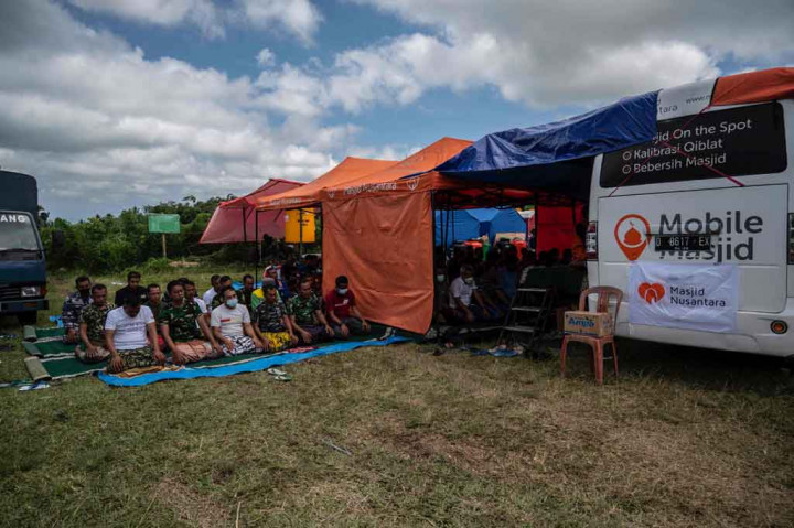 Pengungsi korban erupsi Gunung Merapi bersama para relawan melaksanakan Salat Jumat di Mobile Masjid Nusantara di posko pengungsian Penanggal, Kecamatan Candipuro, Kabupaten Lumajang, Jawa Timur, Jumat, 10 Desember 2021.
