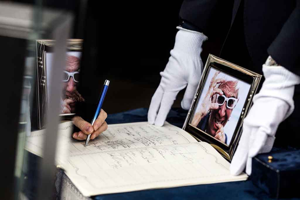 Seorang pelayat menandatangani buku belasungkawa selama upacara pemakaman sutradara Italia Lina Wertmueller di Gereja Seniman di Piazza del Popolo, Roma pada Jumat, 10 Desember 2021 waktu setempat.