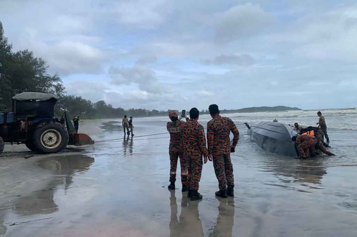 Sebuah kapal ditarik ke pantai setelah terbalik di perairan Tanjung Balau, lepas pantai Johor, selatan Malaysia, Rabu, 15 Desember 2021.