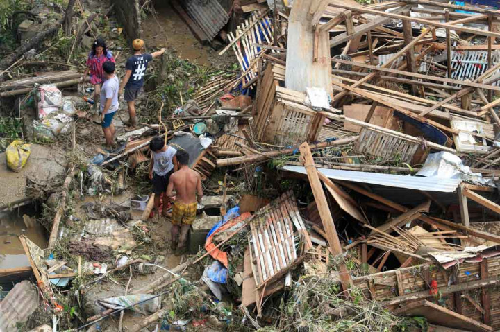 Warga menyelamatkan barang-barang dari rumah mereka yang hancur, sehari setelah topan Rai melanda Talisay, di provinsi Cebu, Filipina pada Jumat, 17 Desember 2021.