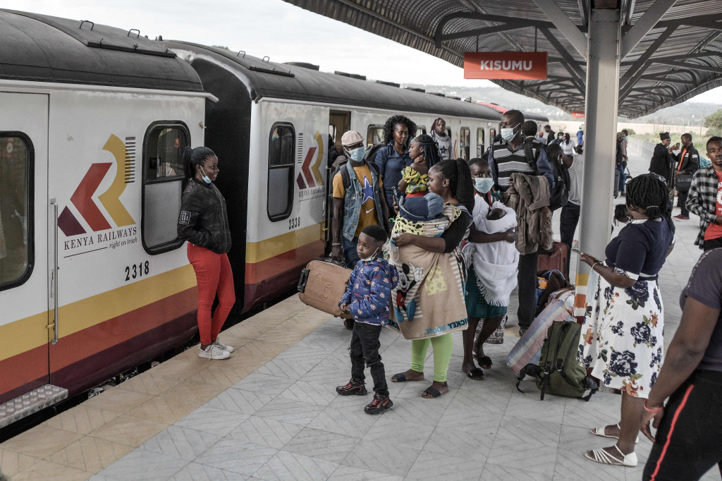 Penumpang berdiri di sebelah kereta api di stasiun kereta Kisumu, pada Jumat, 17 Desember 2021.