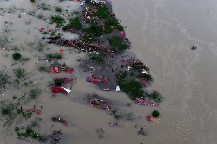 Sementara pandemi covid-19 hingga kini belum juga berakhir. Justru muncul bebera varian baru. Di India, korban meninggal akibat covid-19 banyak dimakamkan di pinggiran Sungai Gangga. Namun karena banjir musiman, ratusan jenazah ditemuakn terapung di sungai yang dianggap suci di negara tersebut. AFP Photo/Sanjay Kanojia 