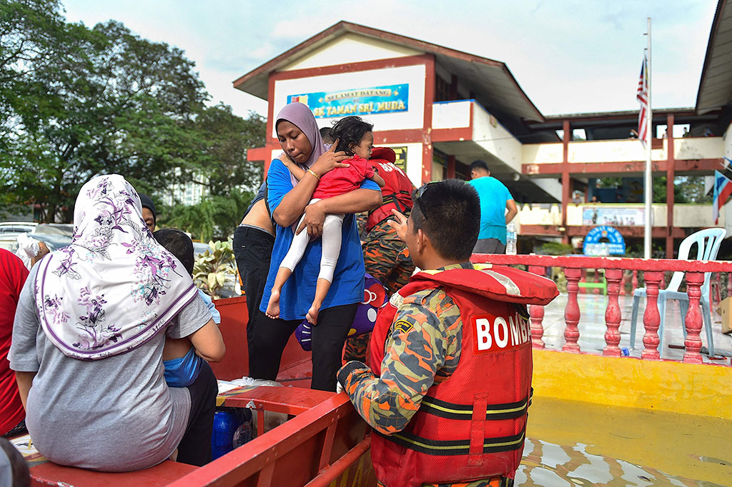 Di Kota Shah Alam, beberapa daerah masih terendam air, sementara personel militer dengan menggunakan perahu membagikan makanan kepada warga yang terjebak di rumah mereka dan tempat penampungan pemerintah.