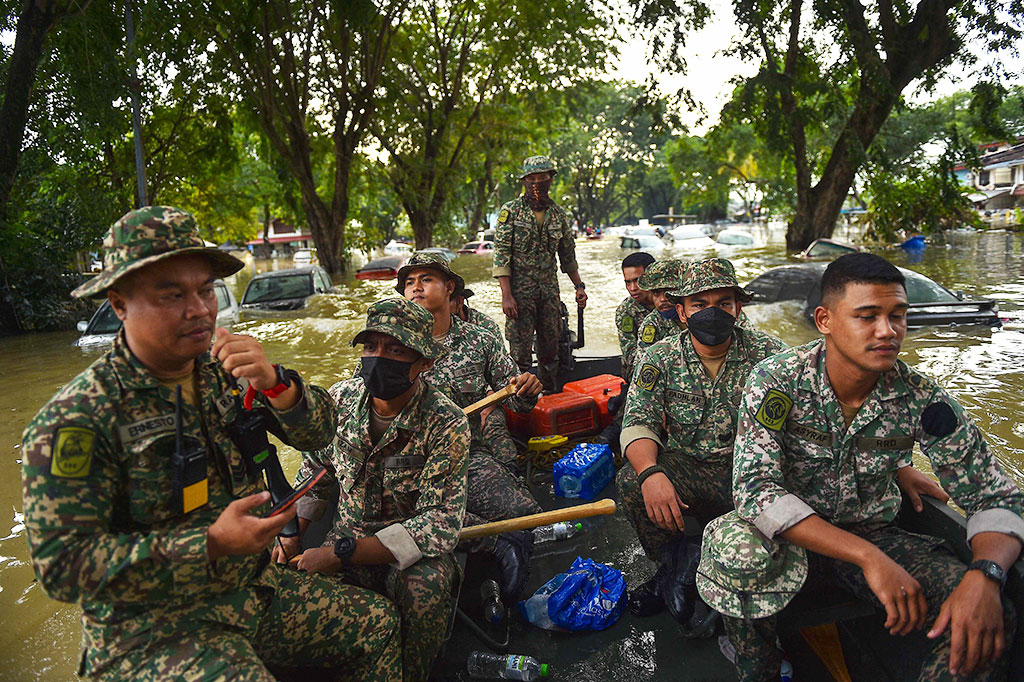 Militer menggunakan perahu untuk mengevakuasi warga yang terjebak di rumah mereka setelah banjir besar melanda Malaysia. Hingga kini jumlah korban meninggal akibat banjir bandang di Negeri Jiran meningkat menjadi 14, sementara lebih dari 70 ribu mengungsi.