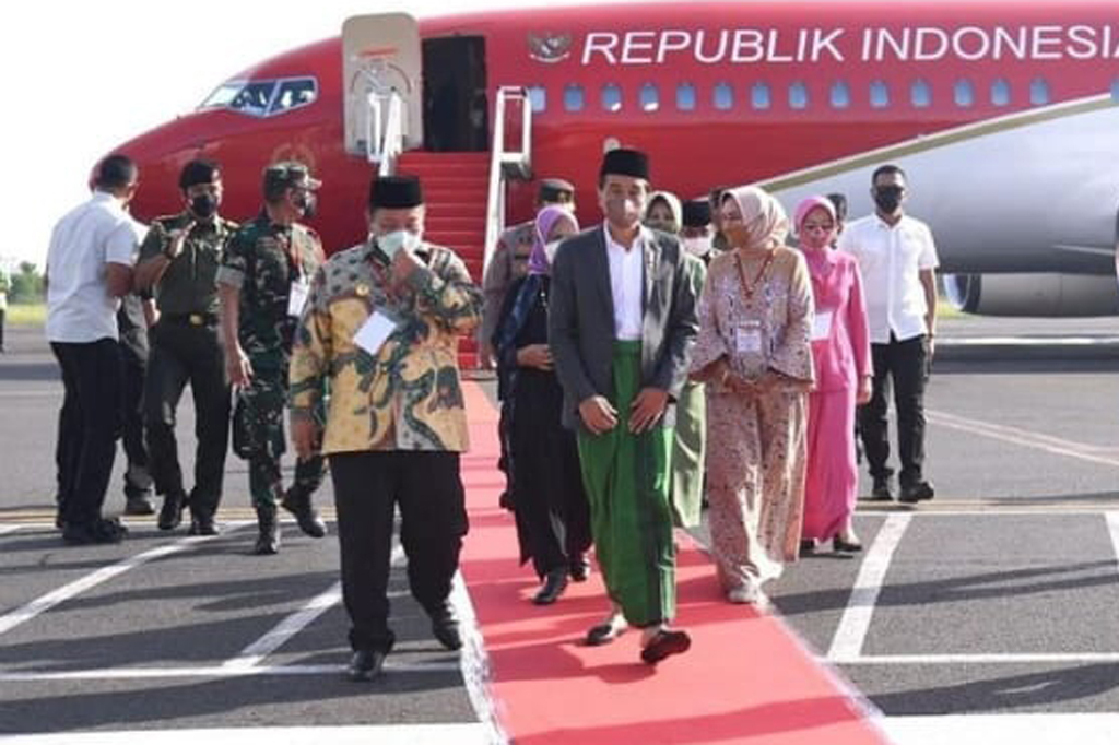 Kepala Negara tampak mengenakan kemeja putih dipadukan jas berwarna abu-abu dengan bawahan sarung berwarna hijau, mengenakan sepatu selop berwarna hitam, dan mengenakan kopiah. Sementara Ibu Negara tampak mengenakan baju terusan berwarna gelap dengan motif kebiruan serta jilbab atau kerudung berwarna ungu.