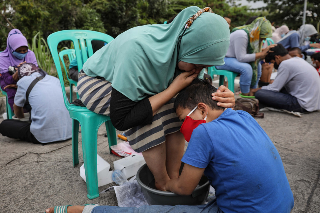 Anak mencuci kaki ibu saat acara cuci kaki ibu massal di kawasan Duri Pulo, Jakarta, Rabu, 22 Desember 2021.
