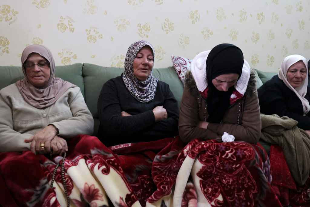 Ibu dari Abd al-Aziz Hikmat Musa (kedua kiri), pria Palestina yang ditembak mati setelah mencoba menabrak tentara Israel dengan mobilnya, berduka dengan kerabat selama pemakamannya di Desa Mirka dekat Kota Jenin, Tepi Barat utara, pada Selasa, 22 Desember 2021.