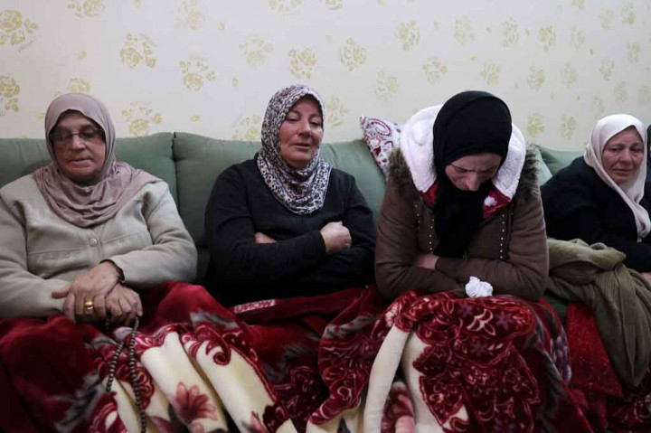 Ibu dari Abd al-Aziz Hikmat Musa (kedua kiri), pria Palestina yang ditembak mati setelah mencoba menabrak tentara Israel dengan mobilnya, berduka dengan kerabat selama pemakamannya di Desa Mirka dekat Kota Jenin, Tepi Barat utara, pada Selasa, 22 Desember 2021.
