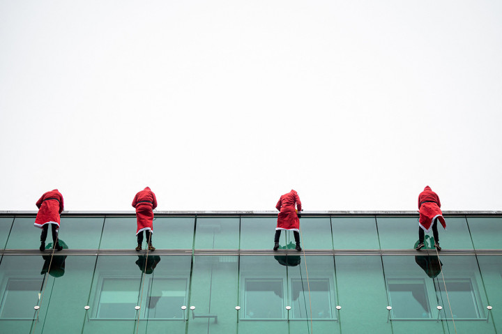 Sejumlah relawan mengenakan kostum Sinterklas melakukan aksi rappeling di RS Anak di Ljubljana, Slovenia, Rabu, 22 Desember 2021.