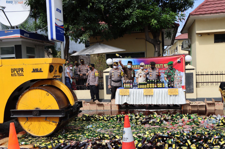 Pemusnahan ribuan botol miras dari berbagai merek ini dilakukan dengan digilas menggunakan alat berat di halaman Polres Tegal Kota, Kamis, 23 Desember 2021.