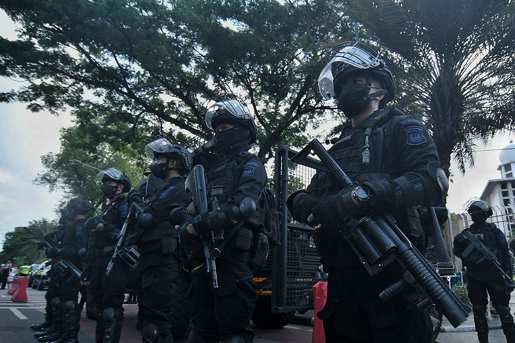 Sejumlah petugas kepolisian berjaga di depan Gereja Katedral, Jakarta, Jumat, 24 Desember 2021. Sebanyak 100 personel kepolisian diturunkan untuk melakukan pengamanan Natal 2021 agar memberikan rasa aman kepada jemaat yang akan melakukan rangkaian ibadah.