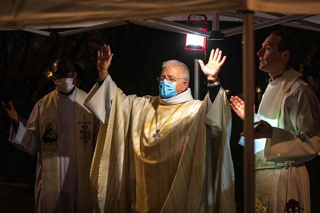 Uskup Arras Olivier Leborgne (tengah) memimpin misa Natal bagi para imigran di dekat kamp mereka di Calais, Prancis utara, pada Jumat, 24 Desember 2021 waktu setempat.