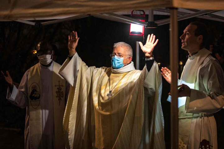 Uskup Arras Olivier Leborgne (tengah) memimpin misa Natal bagi para imigran di dekat kamp mereka di Calais, Prancis utara, pada Jumat, 24 Desember 2021 waktu setempat.