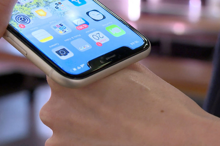 Manajer pemasaran, Amanda Back memindai dengan smartphone sebuah microchip yang dikembangkan oleh perusahaan DSruptive Subdermals dan ditanamkan di tangannya untuk menggunakan kartu kesehatannya di Epicenter Stockholm.