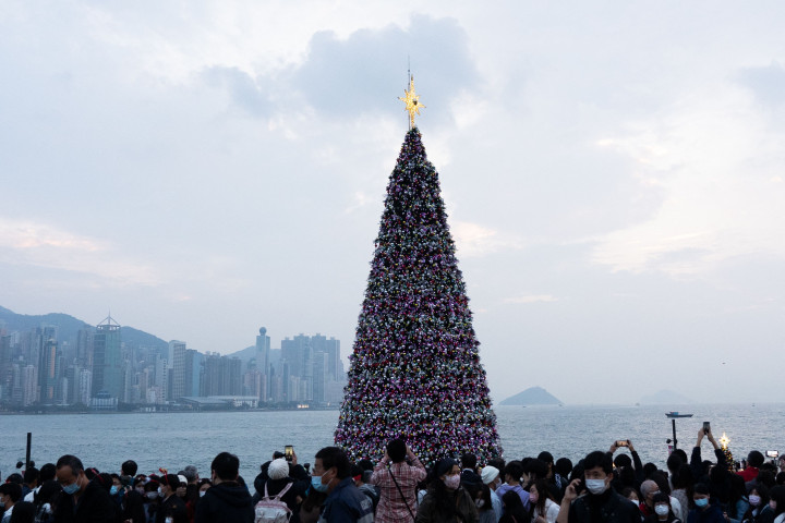 Distrik Budaya Kowloon Barat, Hong Kong menampilkan pohon Natal raksasa yang didekorasi secara glamor dengan karangan bunga dan ornamen, berkilauan dengan lampu meriah yang cerah.