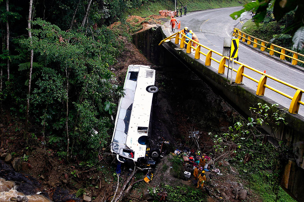 Tim penyelamat bekerja di dekat puing-puing bus yang jatuh ke jurang di jalan yang menghubungkan Medellin dan Bogota, dekat San Luis, Kolombia, pada Senin, 27 Desember 2021 waktu setempat.