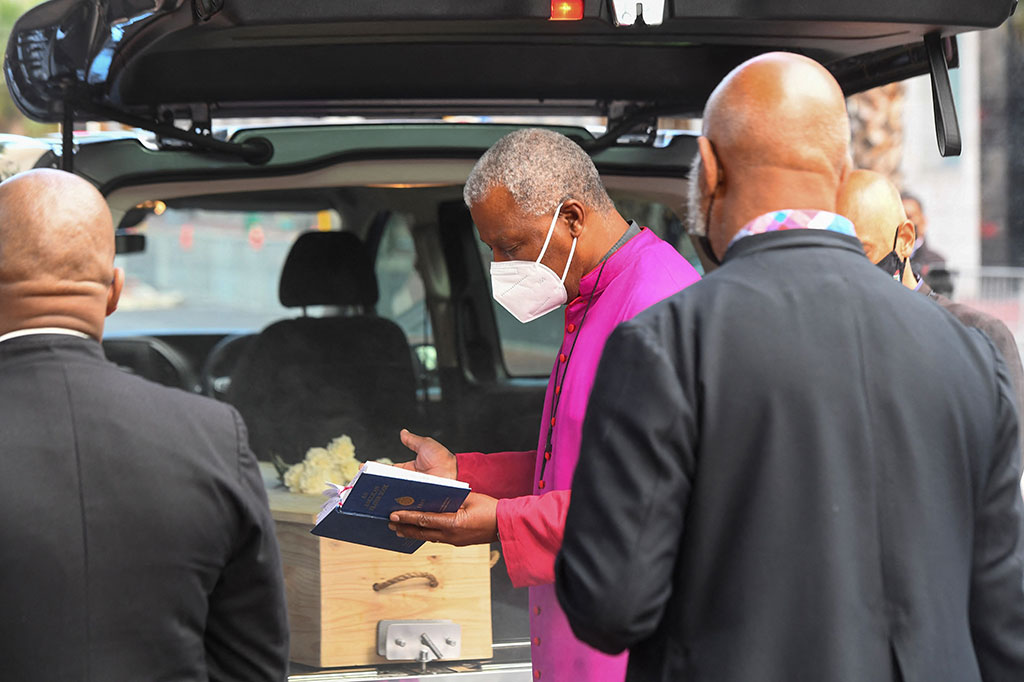 Penerus Tutu, Thabo Makgoba, mengucapkan doa setelah para pastor membakar dupa di atas peti mati sebelum diangkat dari mobil jenazah.