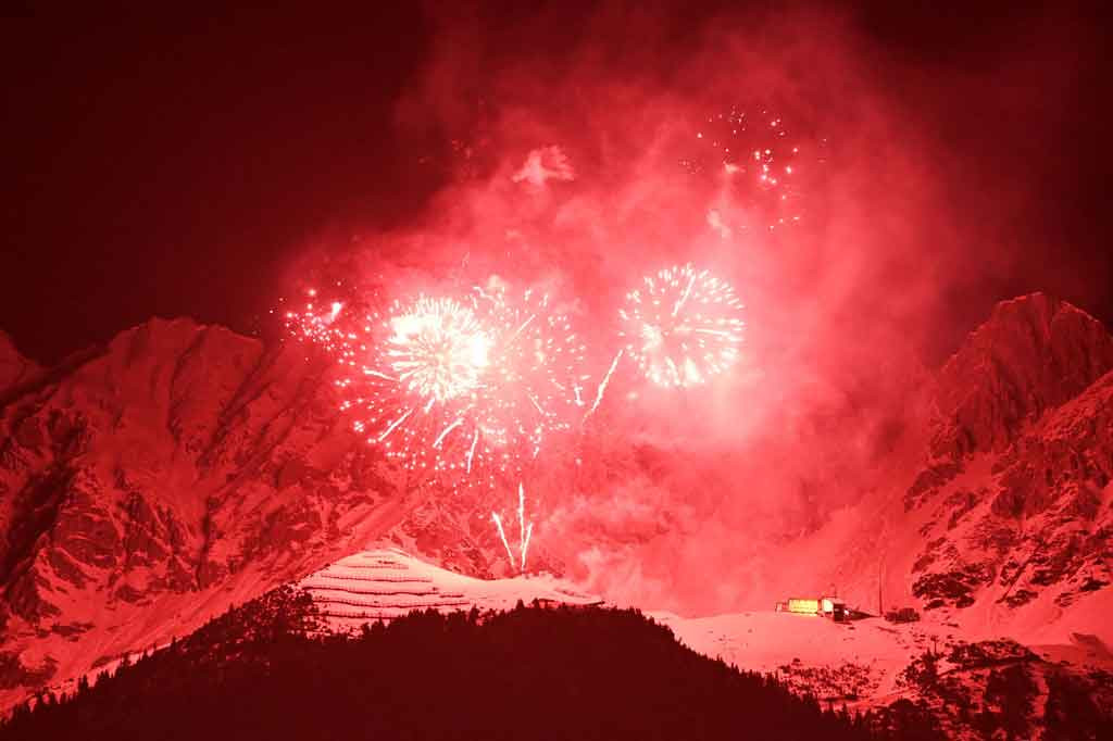 Pesta kembang api terlihat pada awal pergantian tahun di depan Pegunungan Alpen Northern Range (Nordkette) dekat Innsbruck, Austria, pada Sabtu, 1 Januari 2022 dini hari waktu setempat. AFP PHOTO/Christof Stache