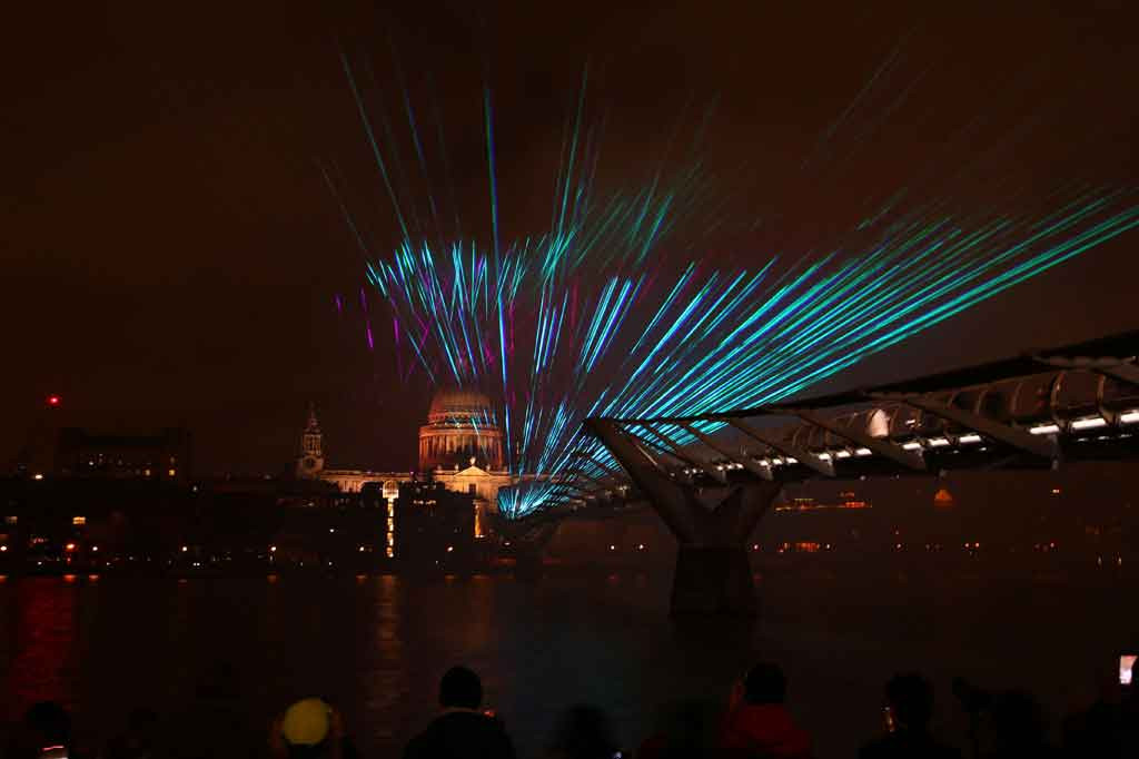 Pertunjukan laser di atas Jembatan Milenium dengan latar belakang Katedral St Paul di pusat kota London pada 1 Januari 2022 dini hari waktu setempat. AFP PHOTO/Hollie Adams