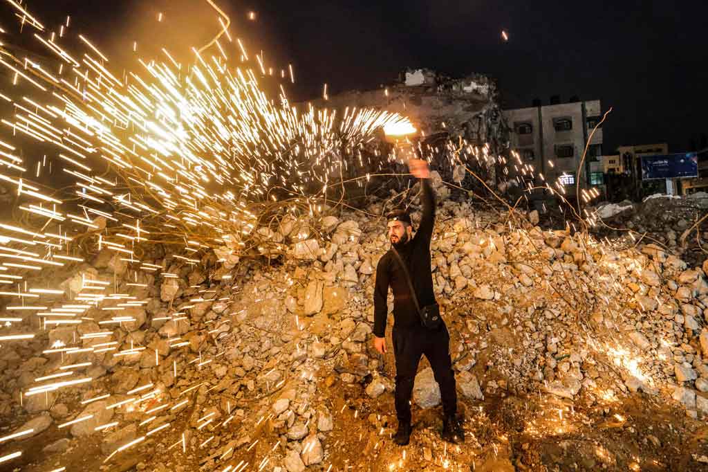 Warga Palestina merayakan malam Tahun Baru dengan menyalakan kembang api di rerunthan rumah di Kota Gaza, pada 1 Januari 2022. AFP PHOTO/Mohammed Abed