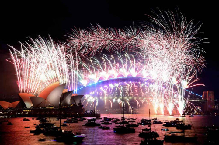 Kembang api Malam Tahun Baru menerangi langit di atas Harbour Bridge dan Opera House, Sydney pada 1 Januari 2022 dini hari waktu setempat. AFP PHOTO/David Gray