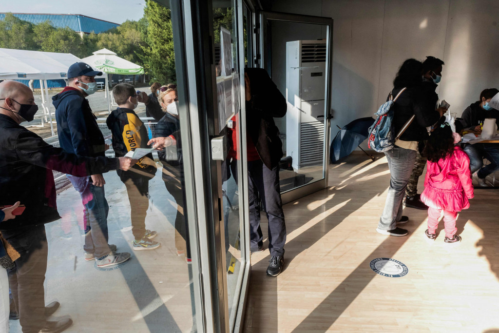 Orang tua mengantre di pusat vaksinasi bersama anak-anak mereka yang akan menerima vaksin covid-19 di Ibu Kota Siprus, Nicosia, Minggu, 2 Januari 2022.