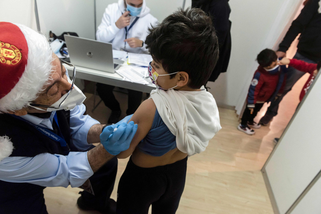 Orang tua mengantre di pusat vaksinasi bersama anak-anak mereka yang akan menerima vaksin covid-19 di Ibu Kota Siprus, Nicosia, Minggu, 2 Januari 2022.