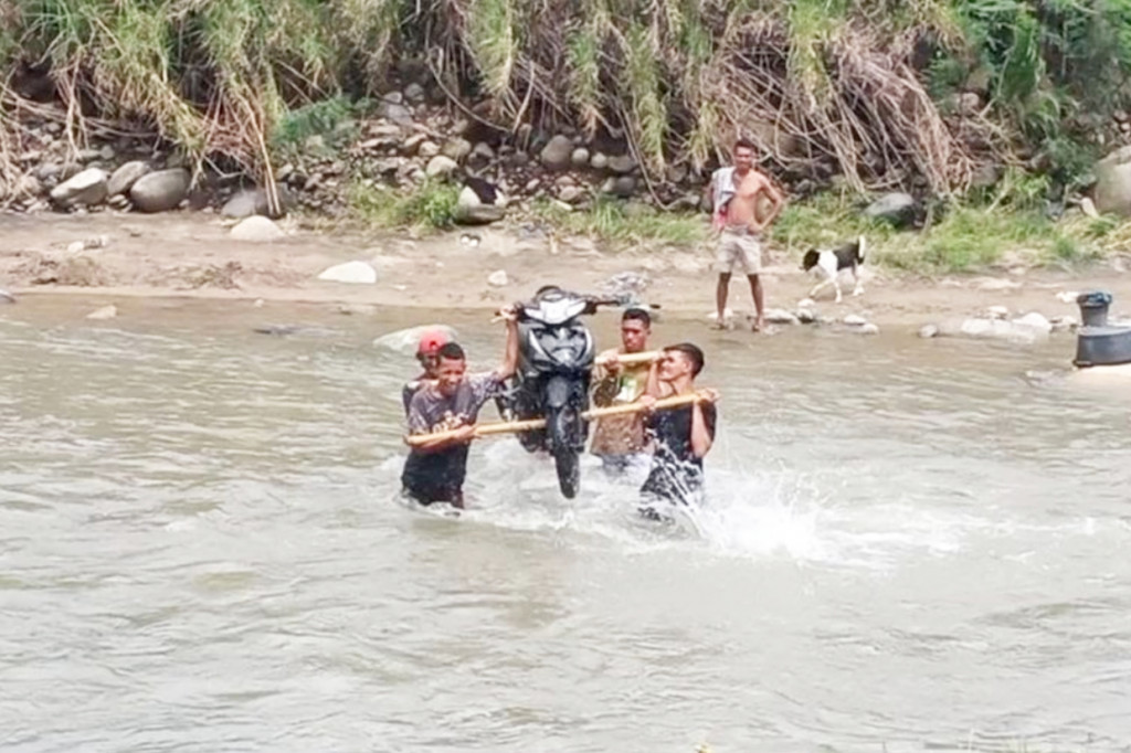 Bencana banjir yang terjadi beberapa waktu lalu membuat sejumlah warga yang ada di Desa Koro Bhera, Kecamatan Mego, Kabupaten Sikka, Nusa Tenggara Timur, harus beralih profesi sementara menjadi jasa pikul kendaraan roda dua.