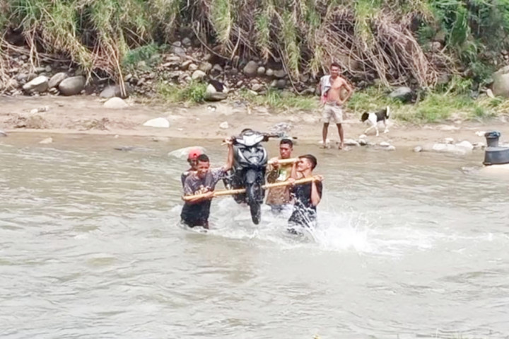 Bencana banjir yang terjadi beberapa waktu lalu membuat sejumlah warga yang ada di Desa Koro Bhera, Kecamatan Mego, Kabupaten Sikka, Nusa Tenggara Timur, harus beralih profesi sementara menjadi jasa pikul kendaraan roda dua.