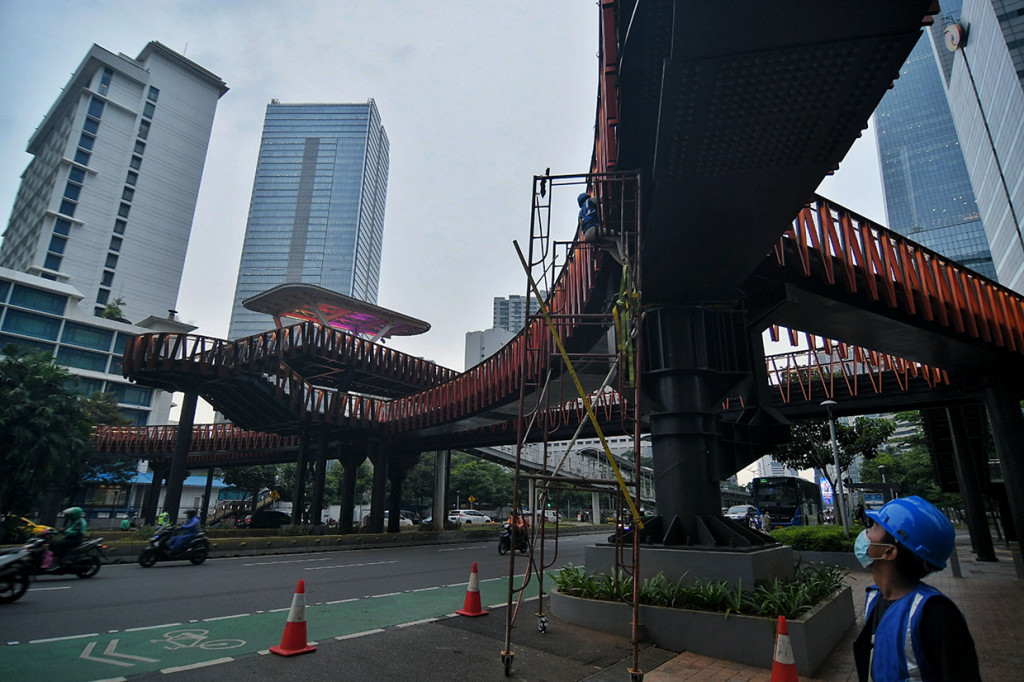 Pekerja menyelesaikan proyek jembatan penyebrangan orang (JPO) Pinisi di kawasan Sudirman, Jakarta, Kamis, 6 Januari 2022. 