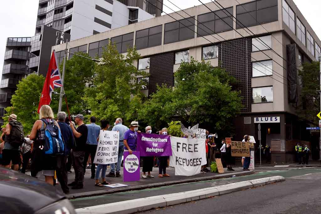 Para penggemar Novak Djokovic berunjuk rasa di tengah hujan pada hari Jumat, 7 Januari 2022, untuk memprotes penahanan superstar tenis itu di Australia. Kasus ini bergema secara global dan memicu reaksi marah dari Serbia.