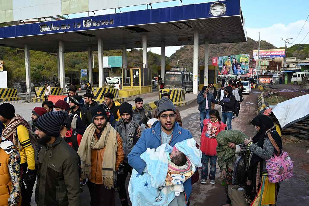 Turis lokal berjalan kembali dari Murree, pinggiran Islamabad pada Sabtu, 8 Januari 2022, setelah insiden yang mengakibatkan sedikitnya 21 orang meninggal dalam kemacetan lalu lintas yang disebabkan puluhan ribu pengunjung yang memadati bukit Pakistan untuk melihat hujan salju yang luar biasa lebat.