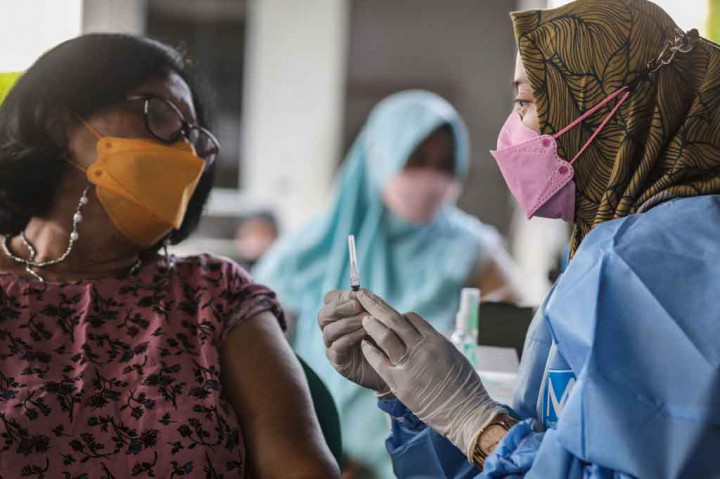 Petugas medis memberikan penjelasan terkait takaran dosis vaksin Covid-19 Pfizer saat pemberian vaksin booster atau dosis ketiga yang didominasi lansia di Puskesmas Kecamatan Pesanggraha, Jakarta Selatan, Rabu, 12 Januari 2022.