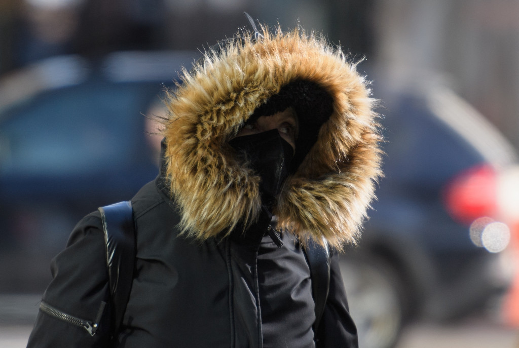 Pejalan kaku mengenakan mantel tebal melawan dingin di New York, Selasa, 11 Januari 2022.