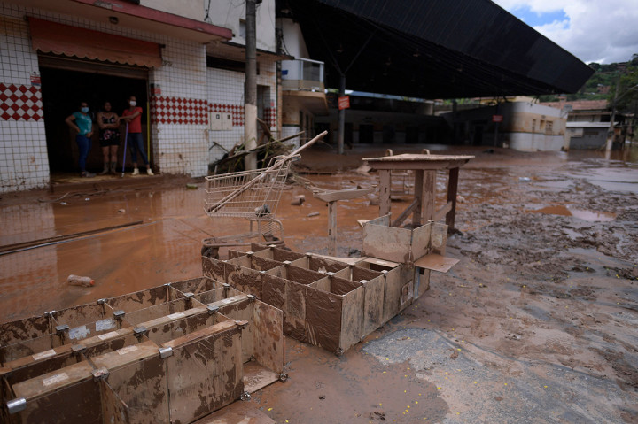 Tanah longsor akibat hujan deras telah menewaskan sedikitnya 12 orang dan pihak berwenang sedang memantau bendungan yang bisa jebol.