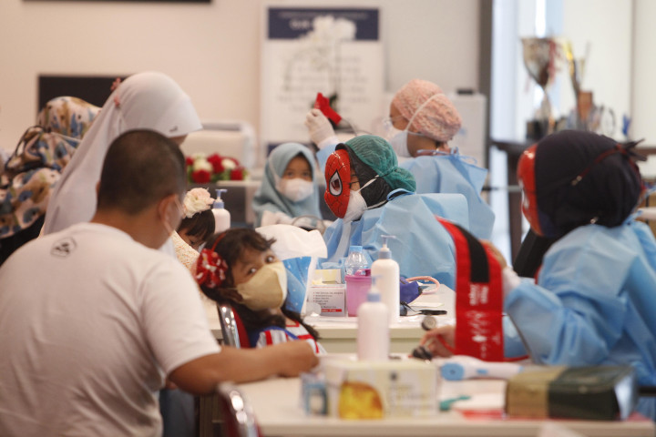 Petugas medis memeriksa tekanan darah dan suhu tubuh anak yang akan mengikuti vaksinasi ke dua di Gedung Otoritas Jasa Keuangan (OJK), Jakarta, Minggu, 16 Januari 2022.