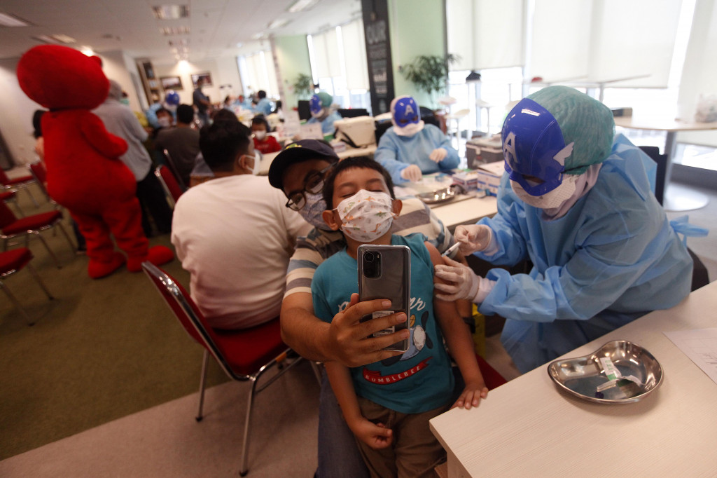 Agar menghilangkan stigma menakutkan dan menarik perhatian anak-anak untuk mengikuti vaksinasi Covid-19, para tenaga medis menggunakan topeng superhero.