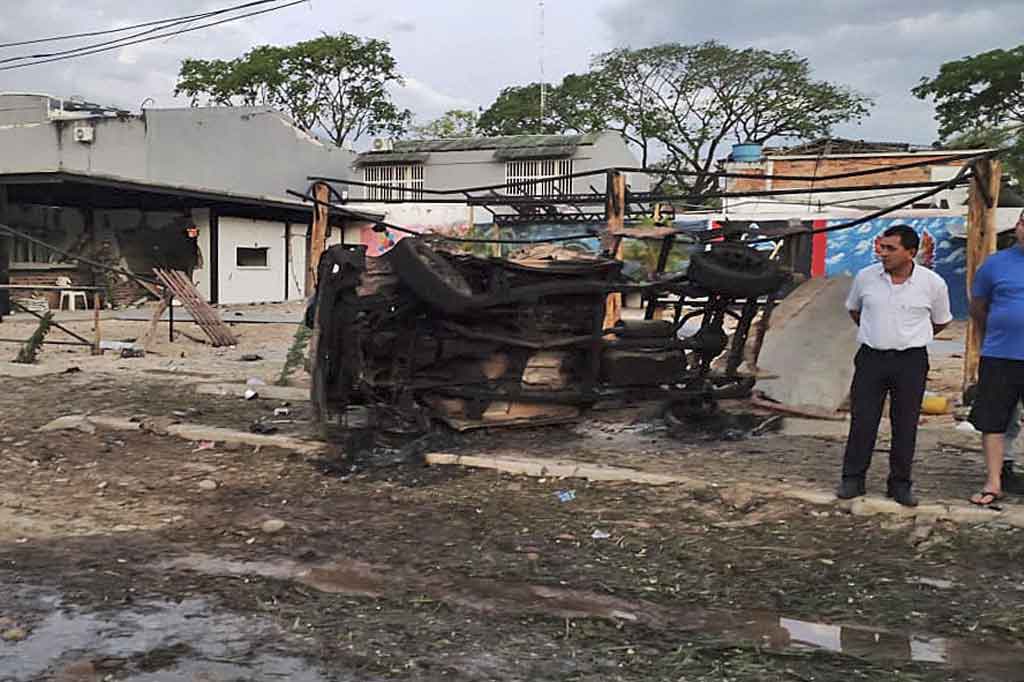 Warga melihat puing-puing mobil dan bangunan yang hancur pascaterjadinya serangan bom mobil di Arauca, Kolombia, pada Kamis, 20 Januari 2022 waktu setempat.