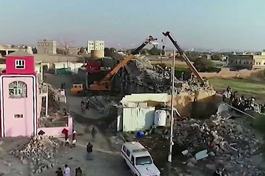 Adegan mengerikan terungkap saat petugas penyelamat menarik jenazah dari bangunan penjara yang hancur dan menumpuk jenazah yang hancur di dekatnya.
