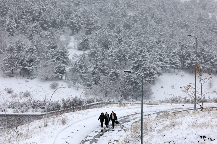 Warga melintasi jalan bersalju di Ankara, 23 Januari 2022.