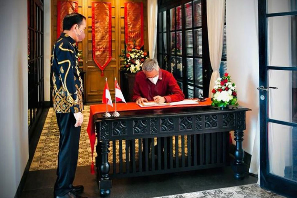 Usai berbincang-bincang, PM Lee kemudian menandatangani buku tamu.