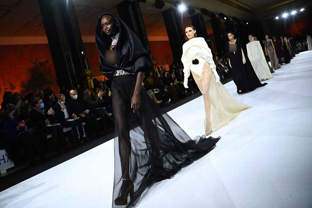 Deretan busana yang ia tampilkan antara lain tailored dress, tunik coklat panjang, draped gown yang menjuntai di bagian belakang atau depan, hingga chiffon dress transparan.