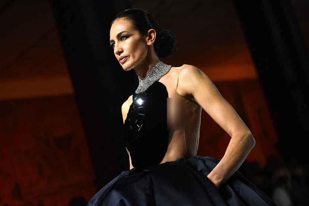 Model Alvarez menutup peragaan busana dengan mengenakan gaun beludru hitam dan satin serta kalung zamrud besar.