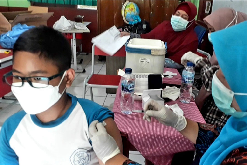 Tenaga kesehatan menyuntikkan vaksin covid-19 dosis kedua kepada seorang anak di SDN Beji 5 Depok, Jawa Barat, Jumat, 28 Januari 2022.
